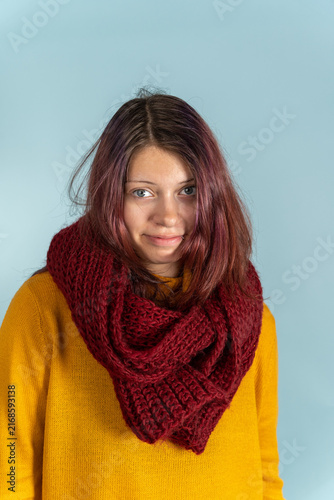 Young woman wearing a red scarf against a light blue background
