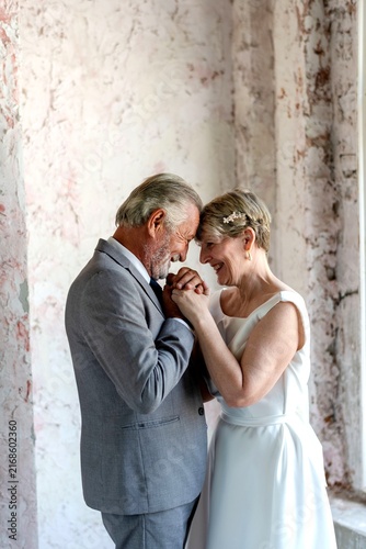 Cuadro en lienzo Elderly couple embracing tenderly indoors