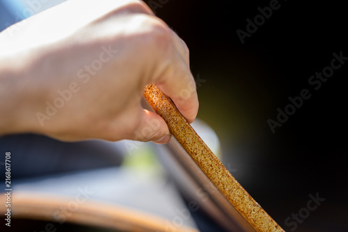 Konstfotografi Human hand holding edge of large thick steel industrial pipe showing rusted metal surface outdoors