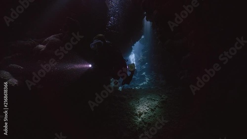 Scuba diver entering coral cave.