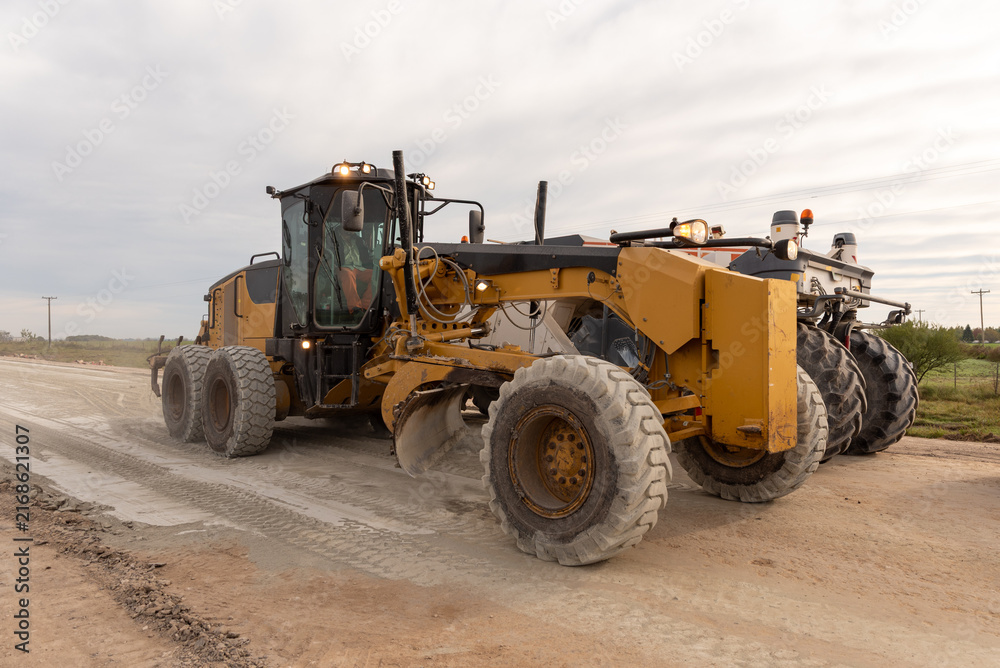 Fototapeta premium Motor grader leveling ground on a rural highway construction project