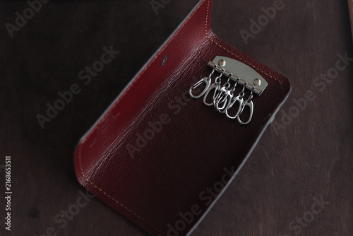Burgundy leather key holder with metal hooks inside. Elegant handmade accessory for organizing keys, featuring minimalist design, premium leather texture, and sophisticated style.