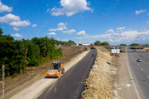 Cuadro en lienzo Highway Construction Site with Asphalt Paving and Road Roller Machinery