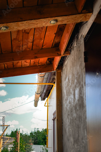 Fotografie Wooden veranda canopy with recessed lights and a yellow gas pipe running along t