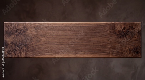 A textured wooden plank displays intricate grain patterns and rich, earthy tones, providing a natural and rustic background for design elements.