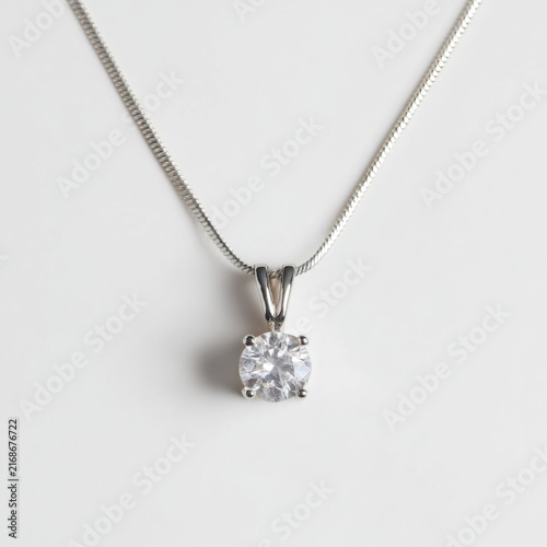 Elegant silver chain necklace with a sparkling round diamond pendant on a soft background