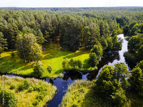 Aerial view of the artificially excavated channel system winding through lush reed beds and dense forest near Lake Engure, Mersrags, Talsi Municipality, Latvia.
