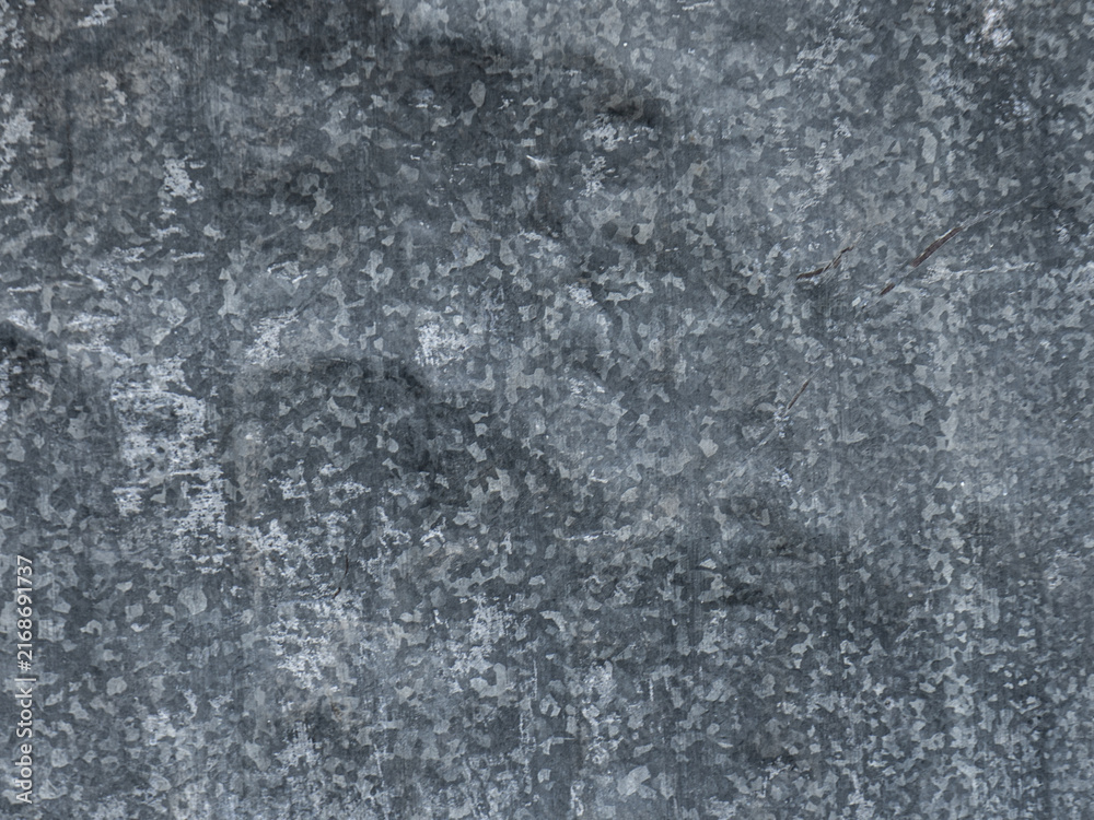 Fototapeta premium Weathered galvanized steel sheet showing worn metallic pattern with natural daylight