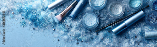 In icy-blue tones, cosmetic products, eyeshadow and lipstick. Wide banner for online beauty and cosmetics stores.