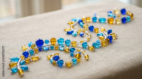 Intricate Blue and Yellow Glass Beads Artfully Arranged in a Decorative Pattern on a Textured Surface