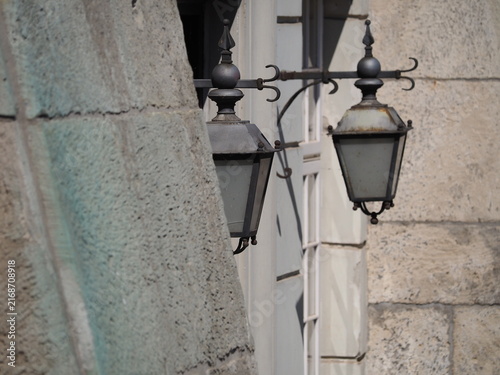 Two street lamps against the background of gray walls