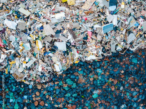 Aerial view of a waste management service site showing a large pile of mixed debris and sorted waste materials in Jurmala, Latvia.