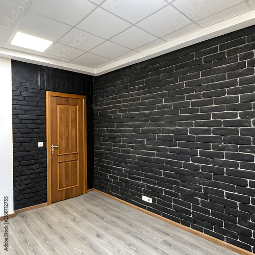 room with a black brick wall