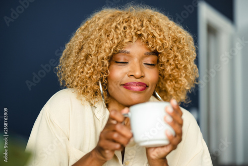 Woman Enjoys a Warm Drink in a Cozy Indoor Setting