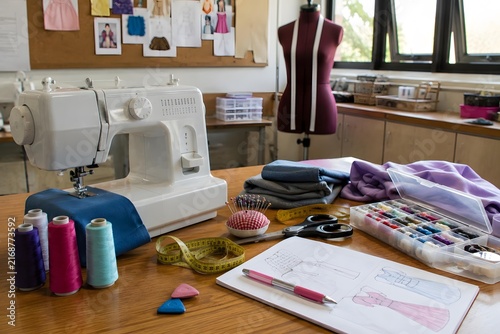 sewing workstation with white machine and dress design sketches