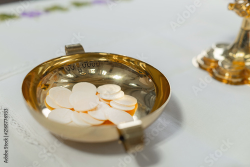 Foto During a holy mass, communion hosts rest in a gold dish on the altar of the catholic church