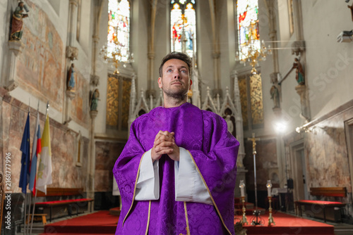 Foto A catholic priest stands with hands clasped during a religious ceremony in a church in Europe