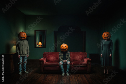 People wearing Halloween pumpkins on heads in the dark room
