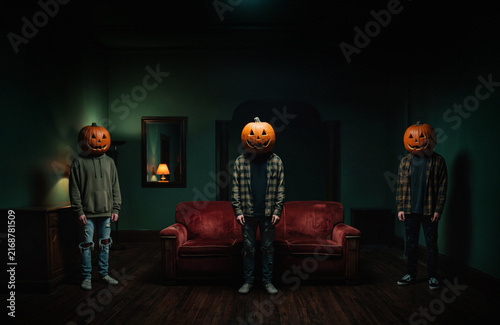 People wearing Halloween pumpkins on heads in the dark room