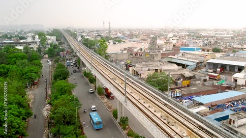 Aerial view of elevated metro rail tracks and urban expressway in New Delhi, India.