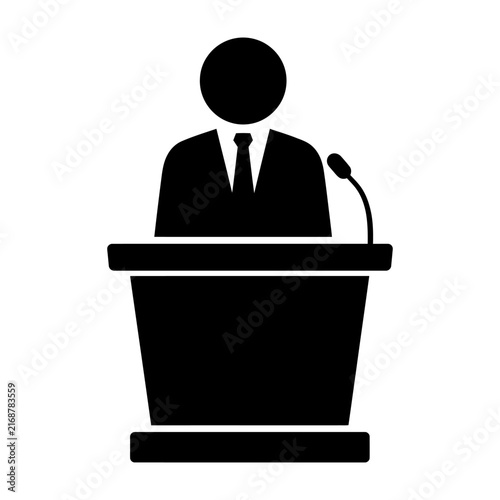 Silhouetted business professional delivers a speech at a podium with microphone during a presentation.