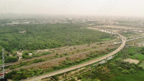 Aerial view of expressway construction in New Delhi, India with urban landscape.