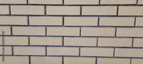 Obraz na plátně Flat lay close-up of a modern light-colored brickwork masonry wall with symmetrical rectangular blocks