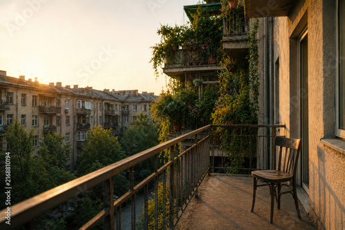 Empty apartment balcony with a single wooden chair. Space for text.