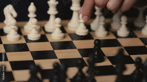 business hand moving a white pawn on a wooden chessboard, strategy