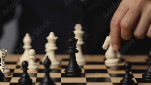 hand holding a white chess knight taking black king, strategy concept