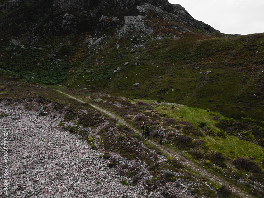 Fototapeta premium Hikers in the rough terrain of Glen Etive
