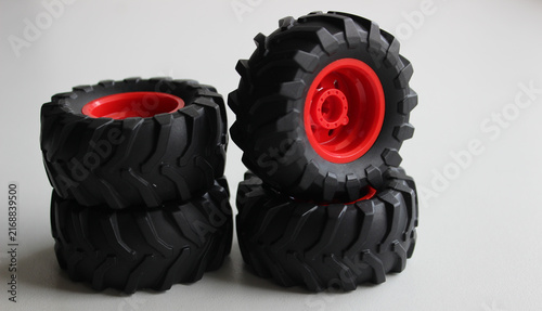 Set of four full size mud off road wheels models stacked on white surface