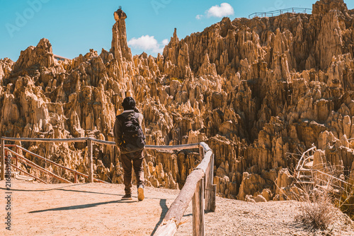 A young Bolivian Latino walking and exploring the beautiful rocky areas of the Valley of the Moon in La Paz, Bolivia - travel concept