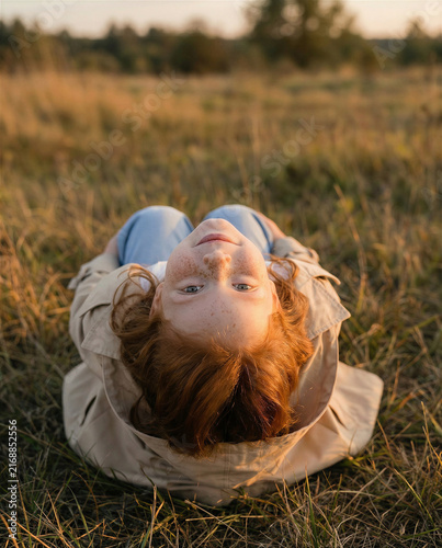 Rustic early autumn photoshoot of a little red-haired girl with a red setter dog near an old barn, warm countryside mood with soft seasonal light