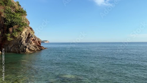 Crystal clear blue sea water along a rugged rocky coastline, pristine  landscape on a sunny summer day