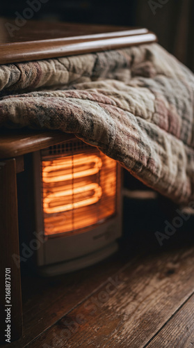 Close-up of Glowing Kotatsu Heater with Quilted Blanket Edge in Cozy Winter Interior