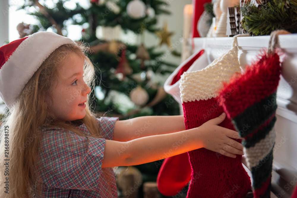 Naklejka premium Child hanging Christmas stocking joyfully.