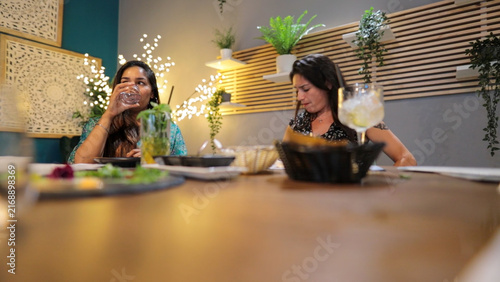 фотографія Two women enjoying a night out, dining in an Indian restaurant, tasting authenti