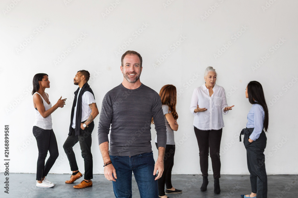 Obraz premium Diverse group of people in casual conversation against a white wall.