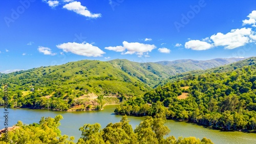 Rolling hills and vibrant green landscape surrounding Gilroy Reservoir near Gilroy Santa Clara County California