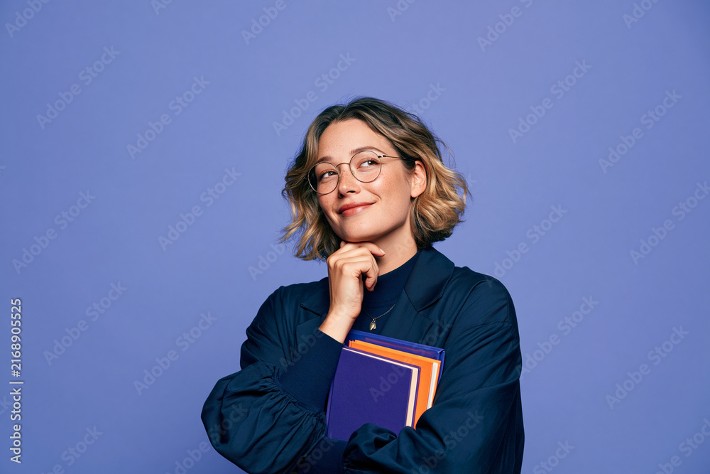 Obraz premium Thoughtful Professional Woman Holding Books in Studio