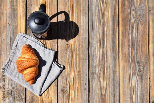 Canvas Print Coffee brewer and croissant on a wooden surface. Copy Space.
