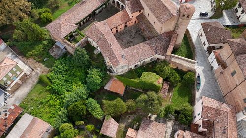 Canvas Print Calendasco Castle with red tile roofs, ancient stone walls and surrounding green