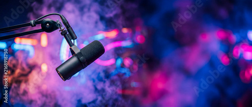 Microphone in a studio with colorful lights and smoke with copyspace