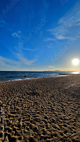 Sunny beach with textured sand and blue sky