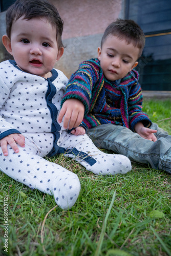 Two cute boys enjoying a playful moment on the grass.