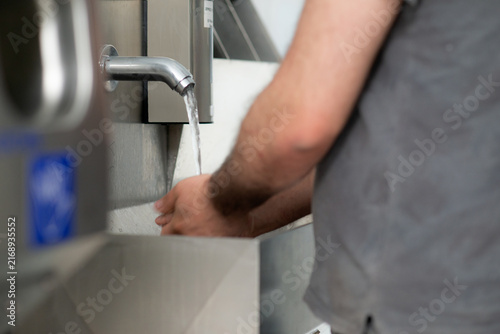Worker Washing Hands at Industrial Hygiene Station
