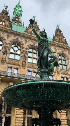 Hygieia fountain sculpture at the inner courtyard of the Hamburg Town Hall (Rathaus) in Germany. Slow motion vertical 4K shot showcasing water dripping from the bronze bowl