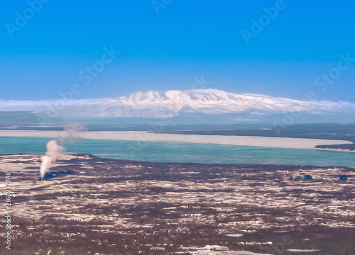 Denali mountain peak rising over scenic coastal waters and dramatic natural wilderness landscape near Anchorage Alaska
