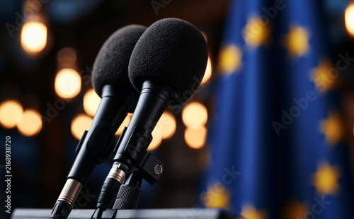 black professional press microphones with foam windscreens mounted on a podium stand